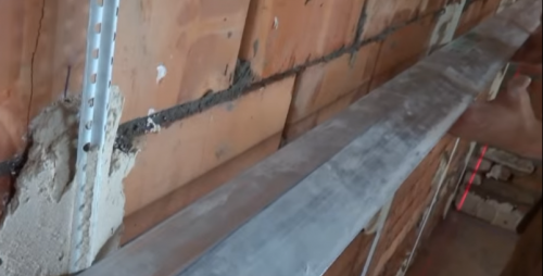 Plâtrer le mur le long des balises de guidage