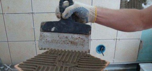 application de colle sur carrelage