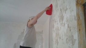 Lisser le papier peint avec une spatule en plastique